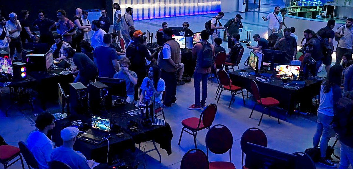 Les joueurs et spectateurs rassemblés autour des setups au BX Dojo